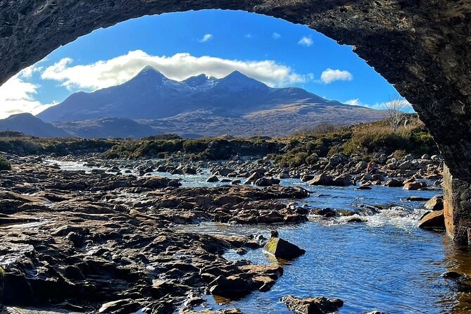 The Cuillin framed by the arch of the old stone bridge at Sligachan, the river running shallow over flat rock