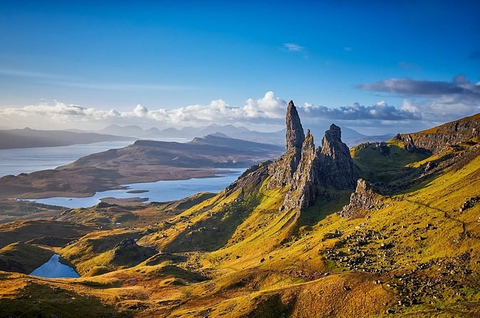 The Old Man of Storr on a clear day, the basalt pinnacle and its neighbours above the lochs, with the Sound of Raasay and the mainland hills beyond