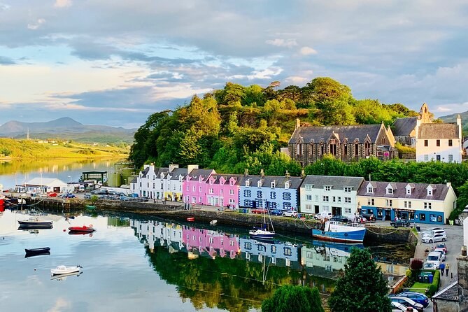 Portree harbour, the row of painted houses in pink, blue and yellow along the quay, reflected in the water with small boats moored