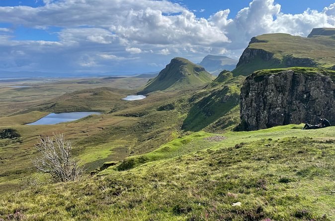 The Quiraing's green landslip ridges and grassy tops, two small lochans in the hollows below and the sea on the horizon